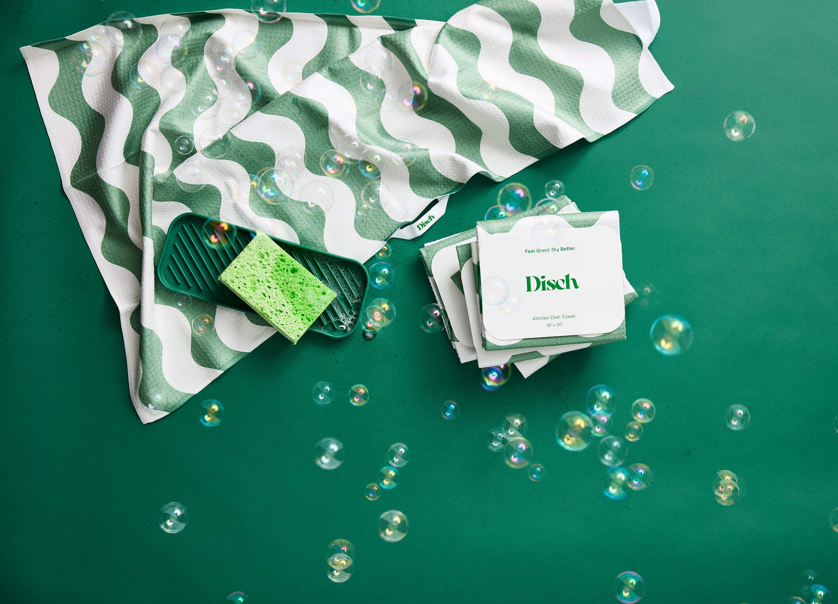 Green and white striped tea towel with a green sponge